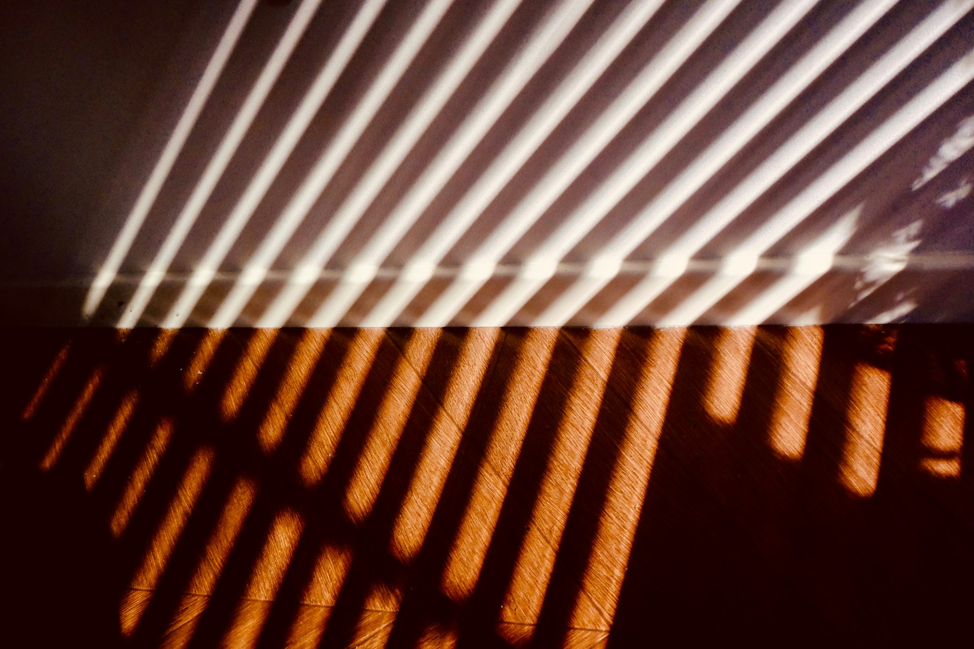 Striped shadow lines casting warm light on a wall